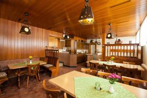 a restaurant with wooden walls and tables and a kitchen at Zur Dorfschänke in Hausen