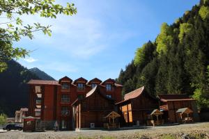 a group of buildings in front of a mountain at Akpinar Hotel in Uzungöl