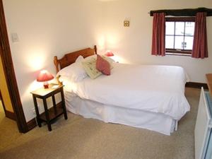 una camera da letto con un letto bianco con due lampade di Stable Cottage - B6062 a Pooley Bridge