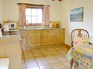 una cucina con armadi in legno, lavandino e finestra di Stable Cottage - B6062 a Pooley Bridge