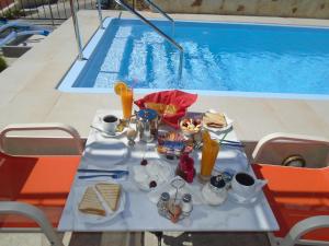 a table with food and drinks next to a swimming pool at Irida in Georgioupolis