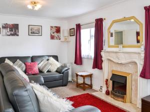 a living room with a couch and a fireplace at Enjoy Your Stay Cottage in Bessingby