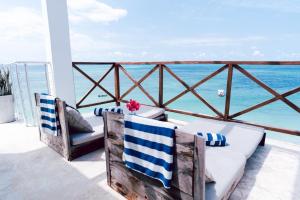 a porch with two chairs and the ocean at Pili Pili Tropical Island in Jambiani