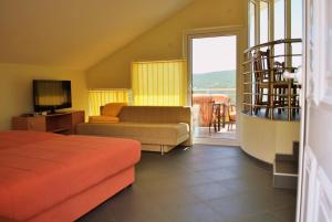 a bedroom with a bed and a couch and a window at Crypto Hills Montenegro in Herceg-Novi