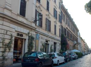 una fila de autos estacionados en una calle al lado de edificios en Casa in Trastevere, en Roma