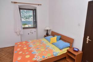 a small bedroom with a bed and a window at Garden Vista Stone House in Kotor