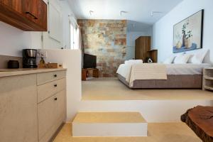 una cucina e una camera da letto con un letto in una stanza di Kyma & Anemos Suites a Naoussa
