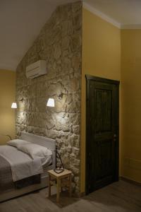 ヴィーコ・デル・ガルガーノにあるGarganoMareBorghi ospitalità diffusaの石壁のベッドルーム1室(ベッド1台付)