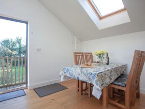a dining room with a table and chairs and a window at The Hayloft - Uk36516 in Germoe