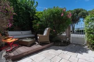 un patio con divano, sedie e fiori di Large house with garden near the sea a Saint-Raphaël