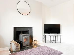 a living room with a fireplace and a mirror at Academy Street Cottage in Tain