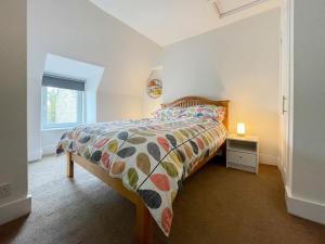 a bedroom with a bed with a colorful comforter at Academy Street Cottage in Tain
