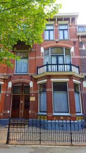 a red brick building with a fence in front of it at City Lodge Stay A while in Zwolle