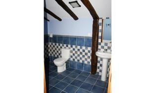 a blue tiled bathroom with a toilet and a sink at Argiñenea in Berástegui
