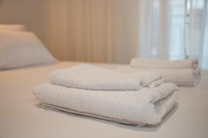 three towels stacked on top of a bed at Aurora Suite in Xanthi