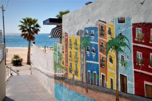 a mural on the side of a wall next to the beach at Apartman CA34 in Villajoyosa
