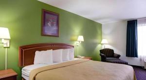 a hotel room with a bed and a chair at Quality Inn & Suites Airport in Austin