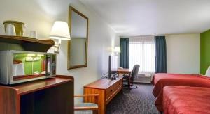 a hotel room with a television and a bed and a desk at Quality Inn & Suites Airport in Austin