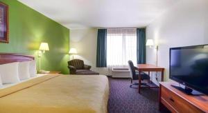 a hotel room with a bed and a flat screen tv at Quality Inn & Suites Airport in Austin