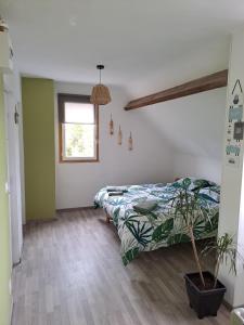 a bedroom with a bed and a potted plant at Lajufe in Cormeilles