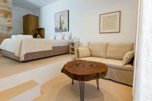 un soggiorno con letto e tavolino da caffè di Kyma & Anemos Suites a Naoussa Altre 37 foto