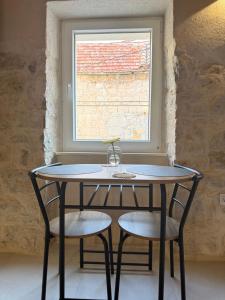 a table and two chairs in front of a window at The Hideaway - Kastel Novi in Kaštela +30 photos