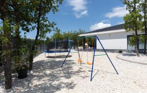 a playground with swings and trees and a building at Lovely Home In Imotski in Imotski