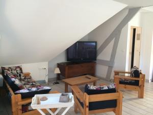 un soggiorno con divani e TV a schermo piatto di La Bossellerie a Courdemanche