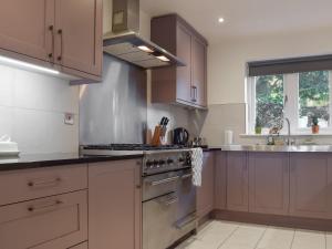 a kitchen with a stove top oven next to a sink at Redwood House in Hoby +13 photos