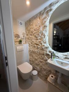 a bathroom with a toilet and a sink and a mirror at The Hideaway - Kastel Novi in Kaštela