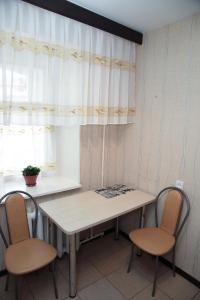 ヤロスラヴリにあるApartments on Sverdlova 11の窓のある部屋(テーブルと椅子2脚付)