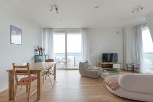 a living room with a table and a couch at Hoch hinaus - Pool am Dach, Rundum Balkon mit Traumaussicht in Vienna
