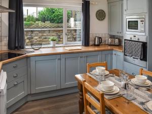 Una cocina con gabinetes azules y una mesa de madera. en New House Farm - Ukc6912, en Leck