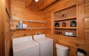 a laundry room with a washer and dryer in a log cabin at Chardonnay Getaway in Pigeon Forge +25 photos