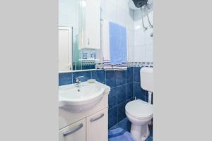 a bathroom with a white toilet and a sink at Apartments Vanja in Bar +36 photos