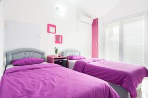 2 łóżka w pokoju z fioletowymi kocami w obiekcie Apartments Vanja w Barze