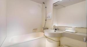 a white bathroom with a sink and a mirror at Hotel Sealuck Pal Utsunomiya in Hanawadamachi +44 photos