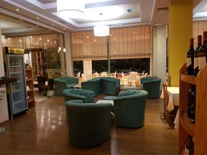 um restaurante com cadeiras verdes e mesas num quarto em Hotel Kaonia em Saranda