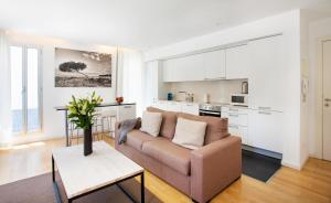 Una sala de estar con un sofá y una cocina. en Durlet Beach Apartments, en Barcelona