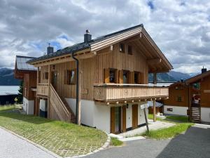 a large wooden house with a balcony on a street at Almhäuser Filzsteinalpe Almhaus 196 in Krimml