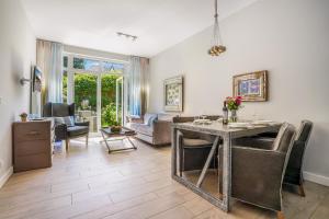 a living room with a table and chairs at Das 54 Grad Nord - Apartments & More in Hörnum