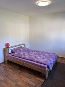 - un lit avec une couette violette dans l'établissement Ferienwohnung im Stadtteil Waiern in Feldkirchen in Kärnten, à Feldkirchen in Kärnten