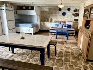 a room with a table and a bed and a couch at La Grange avec Jacuzzi in Loguivy-Plougras +15 photos