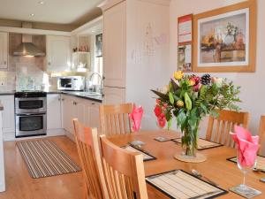 SewerbyにあるYorkshire Rose Holiday Lodgeの花瓶に花が飾られたテーブルのあるキッチン