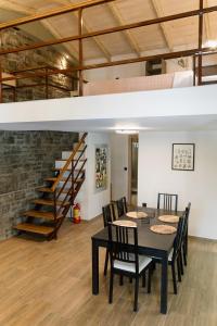 a dining room with a table and chairs and a loft at LOTOS Families Apartments 4 in Konitsa
