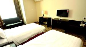 a hotel room with two beds and a flat screen tv at Eminent Hotel in Kampong Kabusik +93 photos