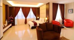 a hotel room with a bed and a chair at Inn Home Hotel Muar in Kampung Tanjung Agas