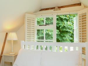 a bedroom with a white bed and a window at Prospect Cottage in Wittersham +10 photos