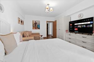 a white bedroom with a large bed and a couch at Spitalul Bagdasar & Obregia - Sudului 507 by MRG Apartments in Bucharest