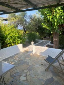 a stone patio with a table and a chair at Niriides Beachfront Resort in Gythio